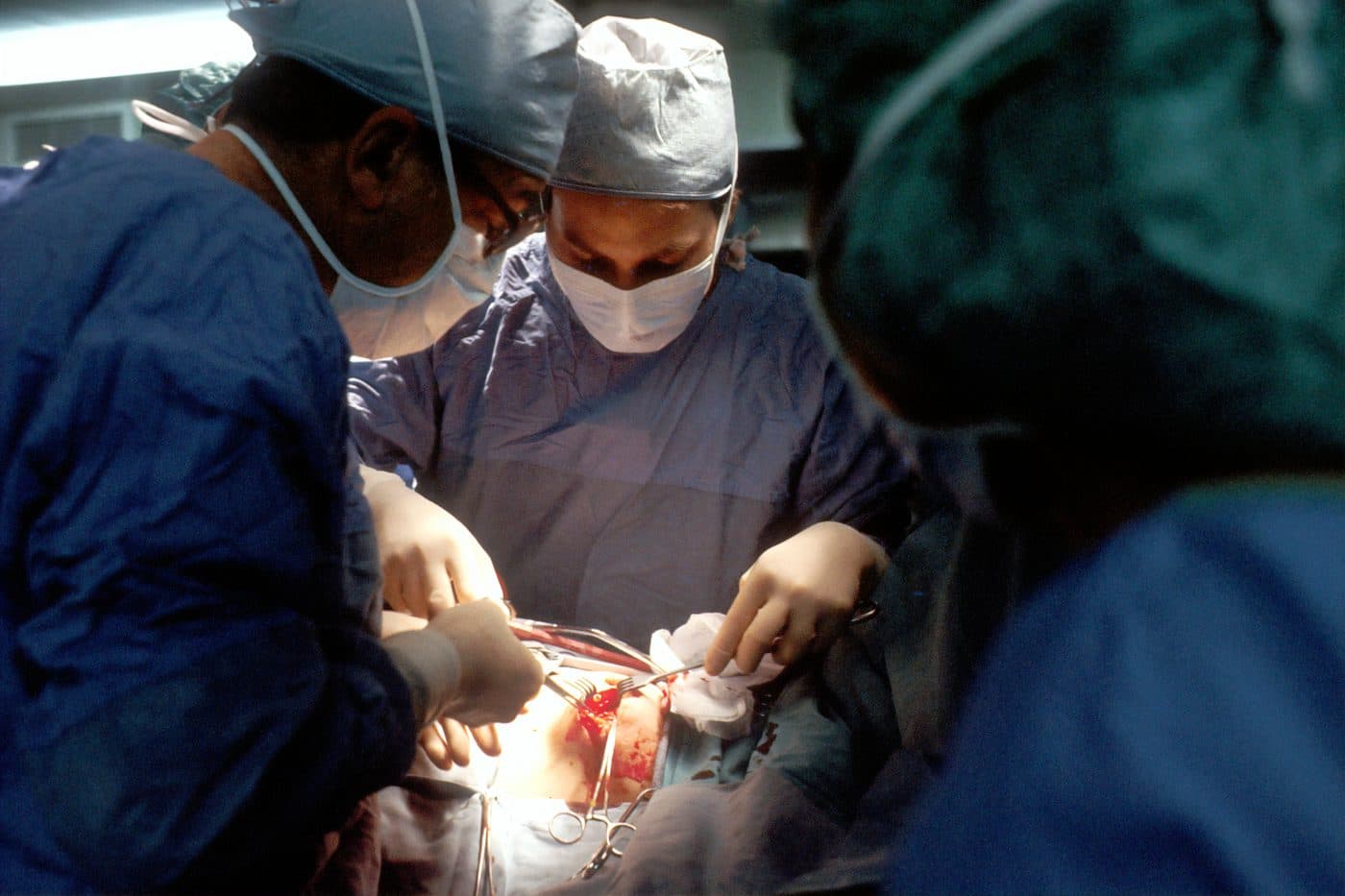 Surgeon and attendant performing an operation
